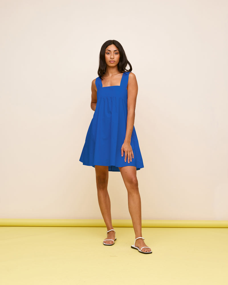 MARGIE TIE MINIDRESS COBALT | Cotton mini dress with a square band bust. The skirt falls into an A-line shape with an exposed back and bow tie closure.