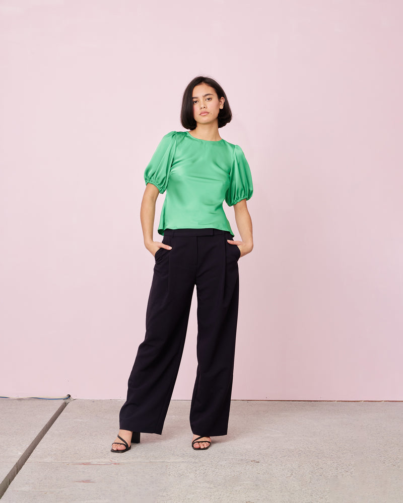 KENDALL SATIN TOP PARAKEET | Bias cut blouse with puff sleeves cut in a luxe emerald satin. It features keyhole button closure at back neck. The short sleeves are elasticated to create a voluminous puff...