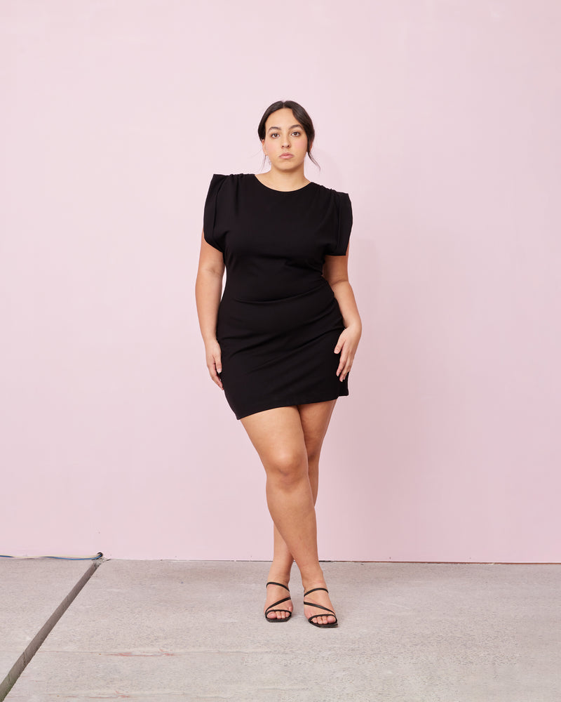 CALVIN MINI DRESS BLACK | 
Capsleeve mini dress designed in a heavy weight knit fabric. Features tucks at the shoulder to create a structured look.