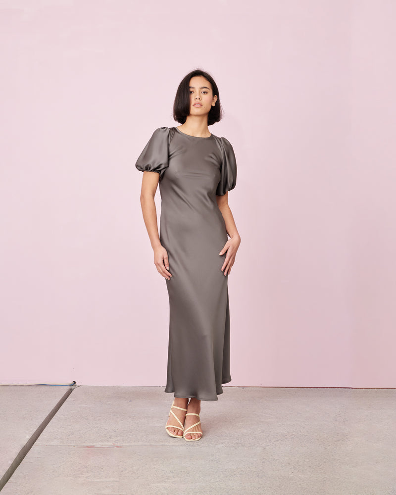 KENDALL SATIN DRESS CHARCOAL | Bias cut satin midi dress with puff sleeves and a keyhole button closure at the back neck. The bias silhouette of this dress gently contours the body, while the satin...
