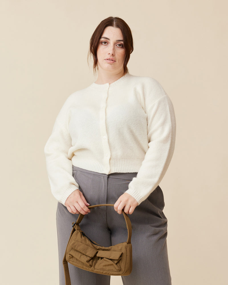 ANNIE CARDIGAN CREAM | Crew neck cardigan with a button-down placket, designed in a cosy alpaca wool blend. This cardigan comes with a detachable bow-tie, to style on the cardigan through the buttonhole, in...