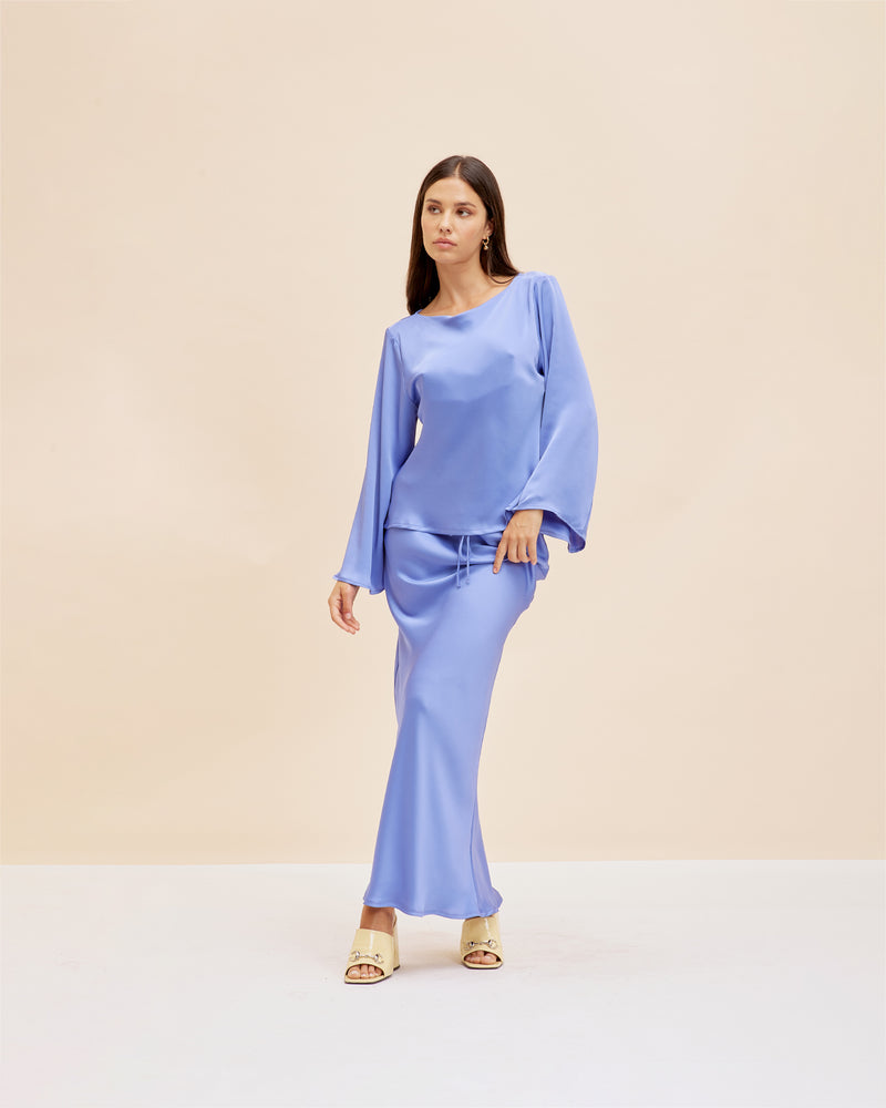 ANDIE BACKLESS TOP PERIWINKLE | Flared sleeve satin blouse designed in a striking periwinkle. This top turns to reveal an open back which contrasts the flared sleeves.