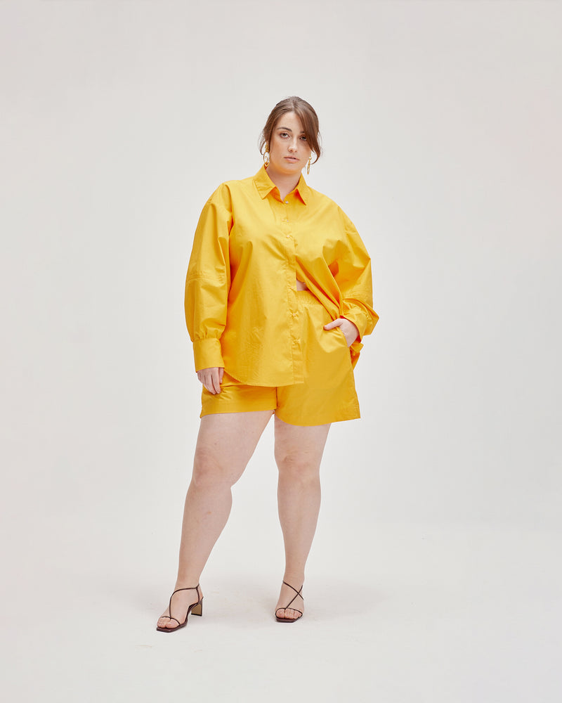 HERO SHORT MARIGOLD | A loose fitting short with an elasticated waistband that sits mid-thigh. Features a faux dome detail and inseam pockets. Light-weight and super comfortable, these shorts can be paired with the matching...