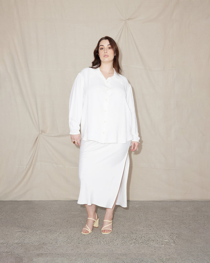 JOHARI SHIRT WHITE | Oversized drop shoulder shirt with long sleeves. With an exaggerated collar and sleeve cuffs that button into tucks, cut from a lustrous white cupro.