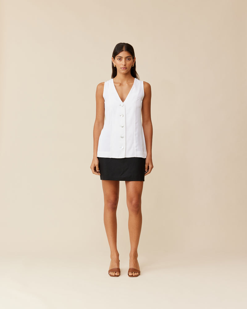 THELMA VEST WHITE | Long-line vest designed in a soft white cupro. Features paneling, a waist tie at the back and white buttons for a sleek look. This piece is versatile in that it can be...
