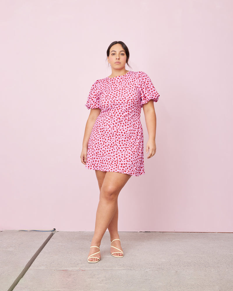 ESME TIE MINI DRESS PINK SCATTER HEARTS | Bias cut mini dress with puff sleeves, waist tie and a keyhole button closure at the back neck. Designed in our RUBY 'scatter hearts' print, the bias silhouette of this...