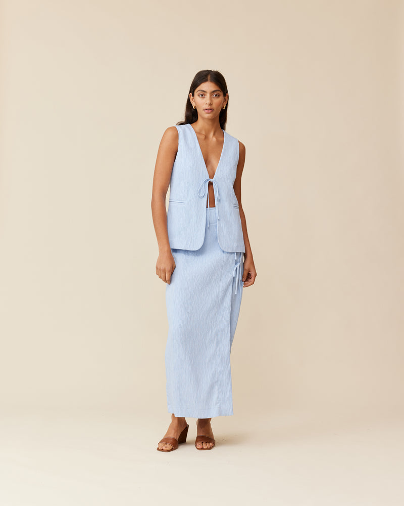 LOU TIE VEST PASTEL BLUE | V-neck vest top with a tie front closure imagined in a pale blue textured fabric. This vest can be worn on its own or layered over shirts & dresses as...