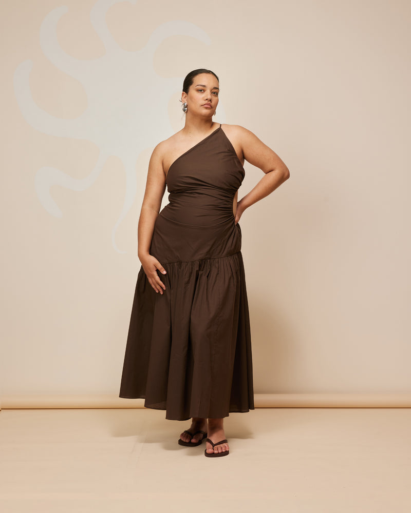 BETTINA CUT OUT DRESS CHOCOLATE | Asymmetrical one shoulder midi dress with a circular cut-out at the waist in a light weight chocolate cotton. This dress is designed to be a stand-out.