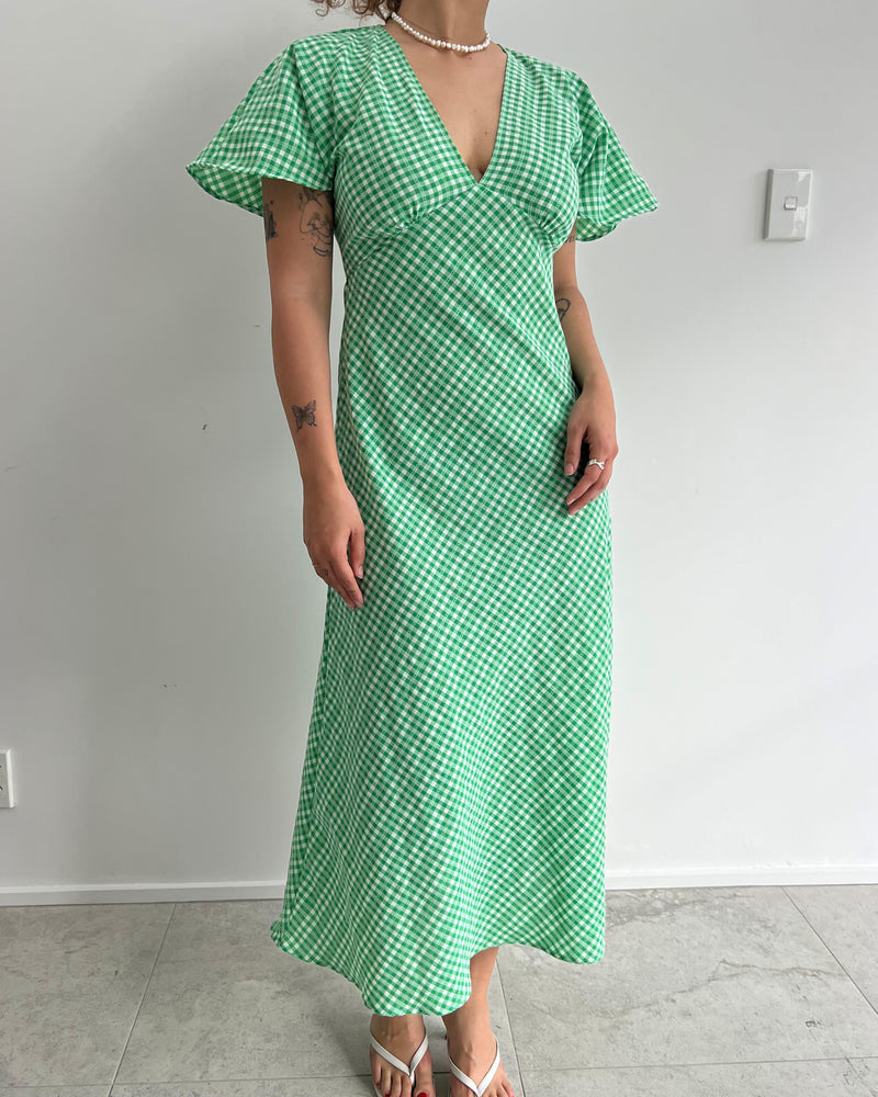 HONEY MIDI DRESS GREEN GINGHAM | V-neck midi dress, made in a lightweight cotton gingham. Fitted around the waist flowing to an A-line skirt, this dress is a timeless piece.
