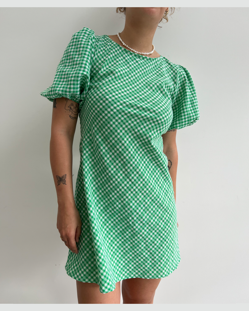 KENDALL GINGHAM MINI DRESS GREEN GINGHAM | Our iconic Kendall Mini dress is back in a playful new green gingham. Features a bias-cut with puff sleeves, and an open back secured by long ties at the back...