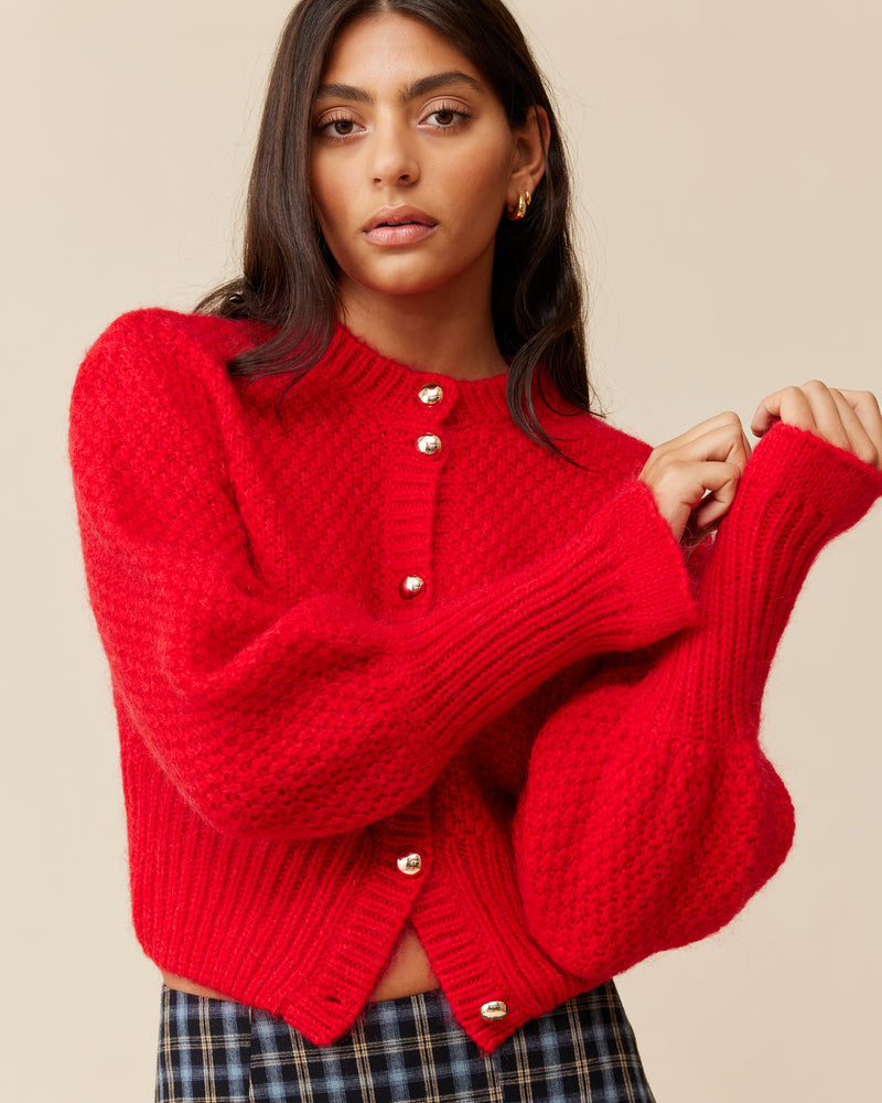 MATILDA CARDIGAN CHERRY | Button-down cardigan with gold metallic dome buttons and a slightly puff-shouldered silhouette. Features an exaggerated flute cuff crafted in a chunky mohair and wool blend.