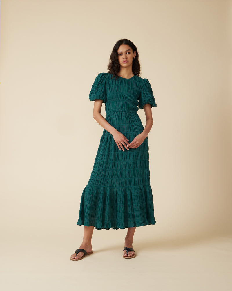 MIRELLA PRAIRIE DRESS PINE | A-line maxi dress that is fitted through the top and continues into an floaty skirt, with a round neckline and short elasticated puff sleeves. The voluminous sleeves make this silhouette...