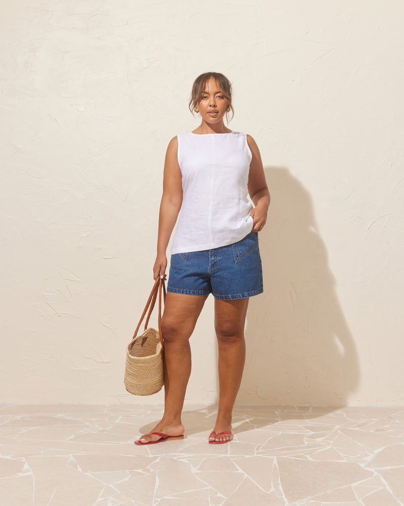 AVA LINEN BOW TOP WHITE | Sleeveless linen high neck blouse cut in a crisp white linen. This piece turns to reveal a chic cut-out back detail with an oversized bow.