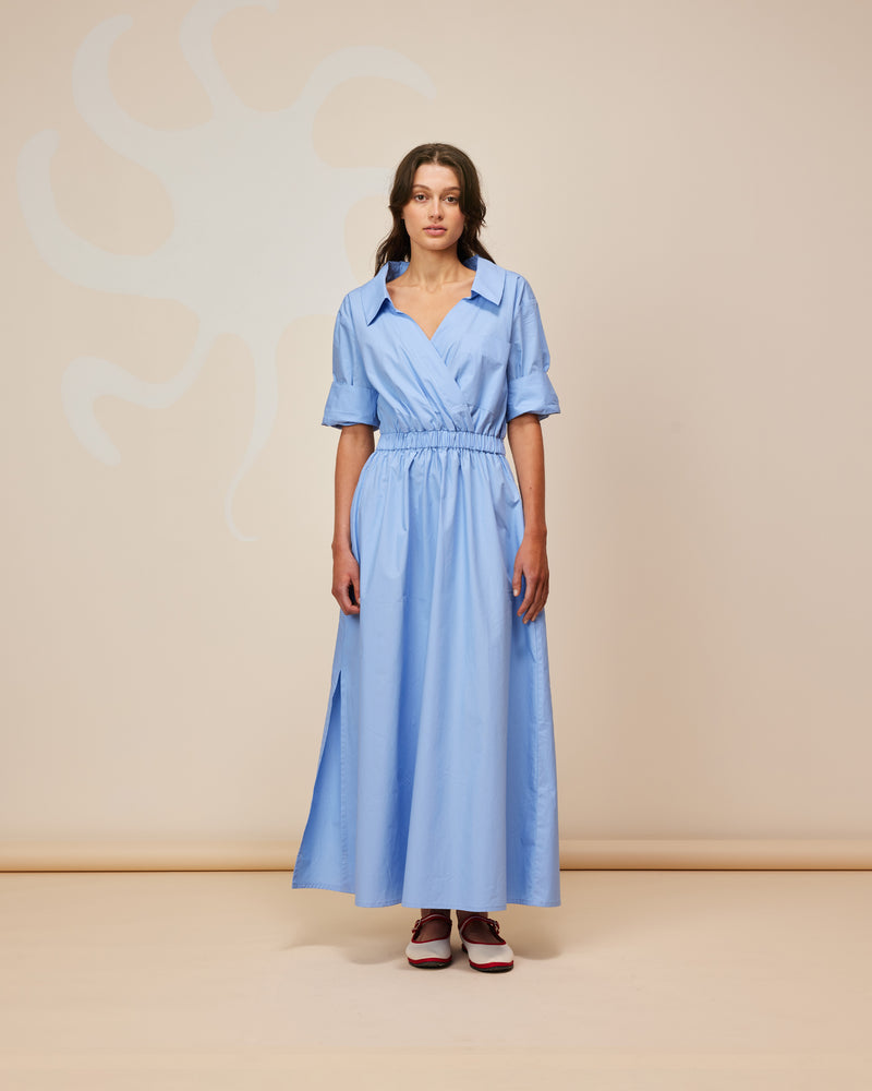 SOOKIE SHIRTDRESS CORNFLOWER | Maxi shirt dress crafted in cornflower cotton with an elasticated waist and short sleeves. This dress is designed with a faux wrap detail with a feature front pocket.