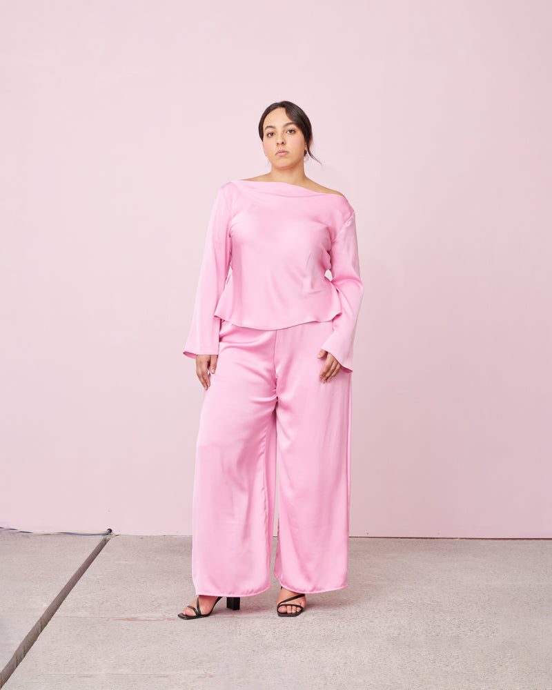 ANDIE SATIN BLOUSE CANDY | 
Flared sleeve satin blouse designed in a lush candy pink satin. This top has a cowl neckline and tie detail at the waist.
 


