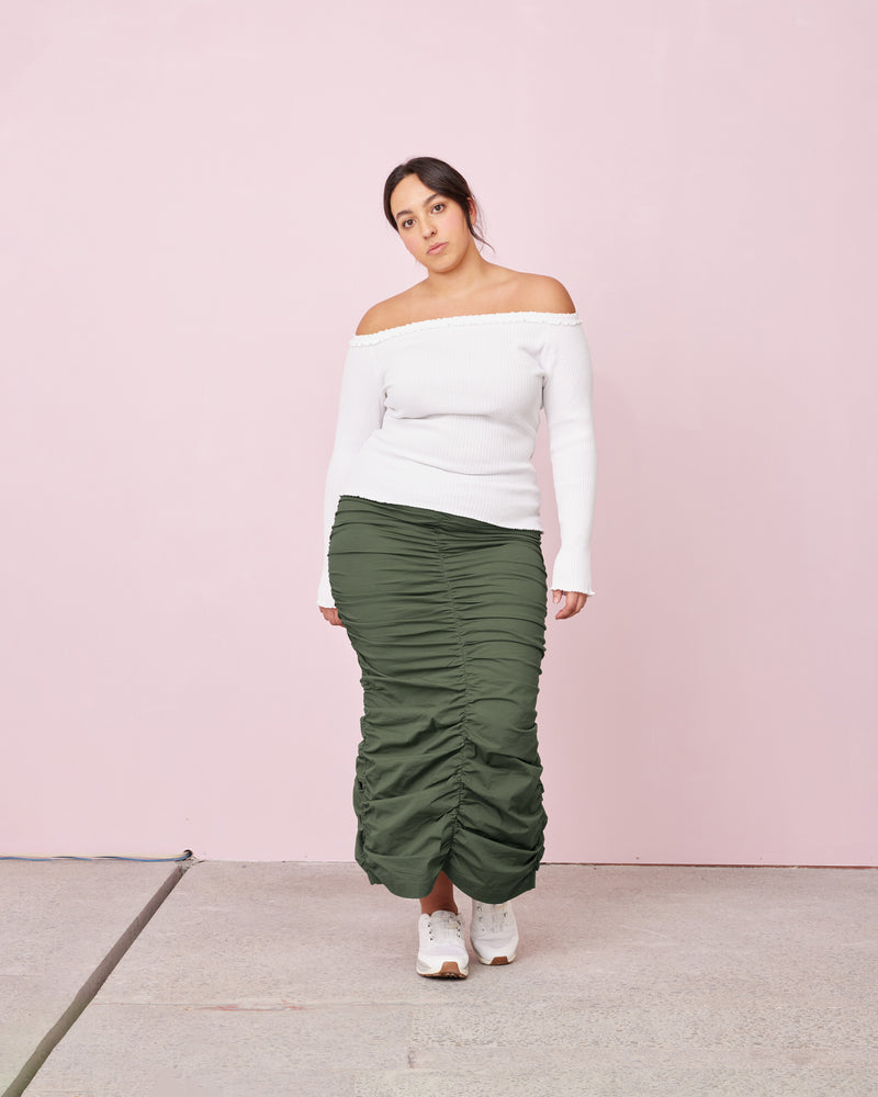 ARIEL MIDI SKIRT KHAKI | Cut from a stretch poplin, this midi skirt is designed to fit tightly to the body, creating a sleek silhouette. 