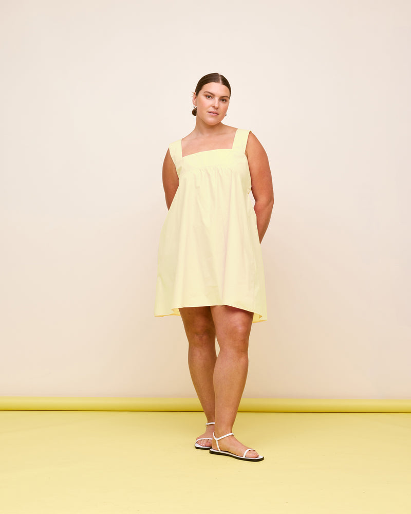 MARGIE TIE MINI DRESS BUTTER | Cotton mini dress with a square band bust. The skirt falls into an A-line shape with an exposed back and bow tie closure.