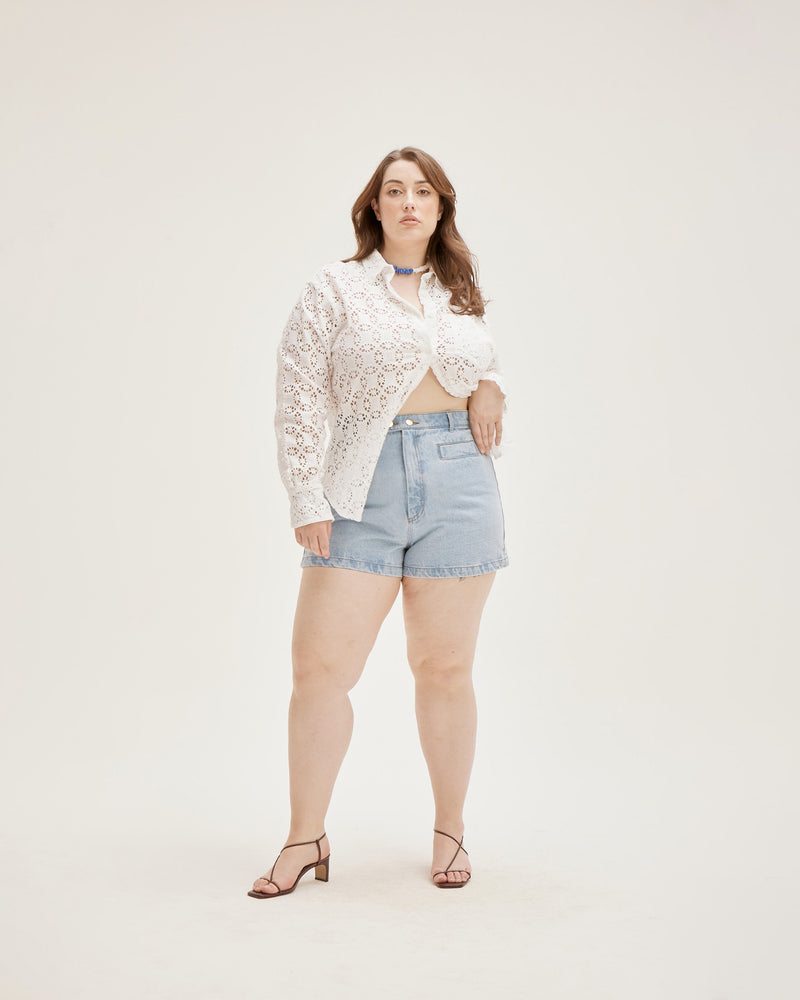 SUZIE DENIM SHORT LIGHT BLUE | Fitted highwaist short with a double button closure detail and slightly flared hem in a light blue denim. Small features such as an asymmetrical seam across the back and wide...
