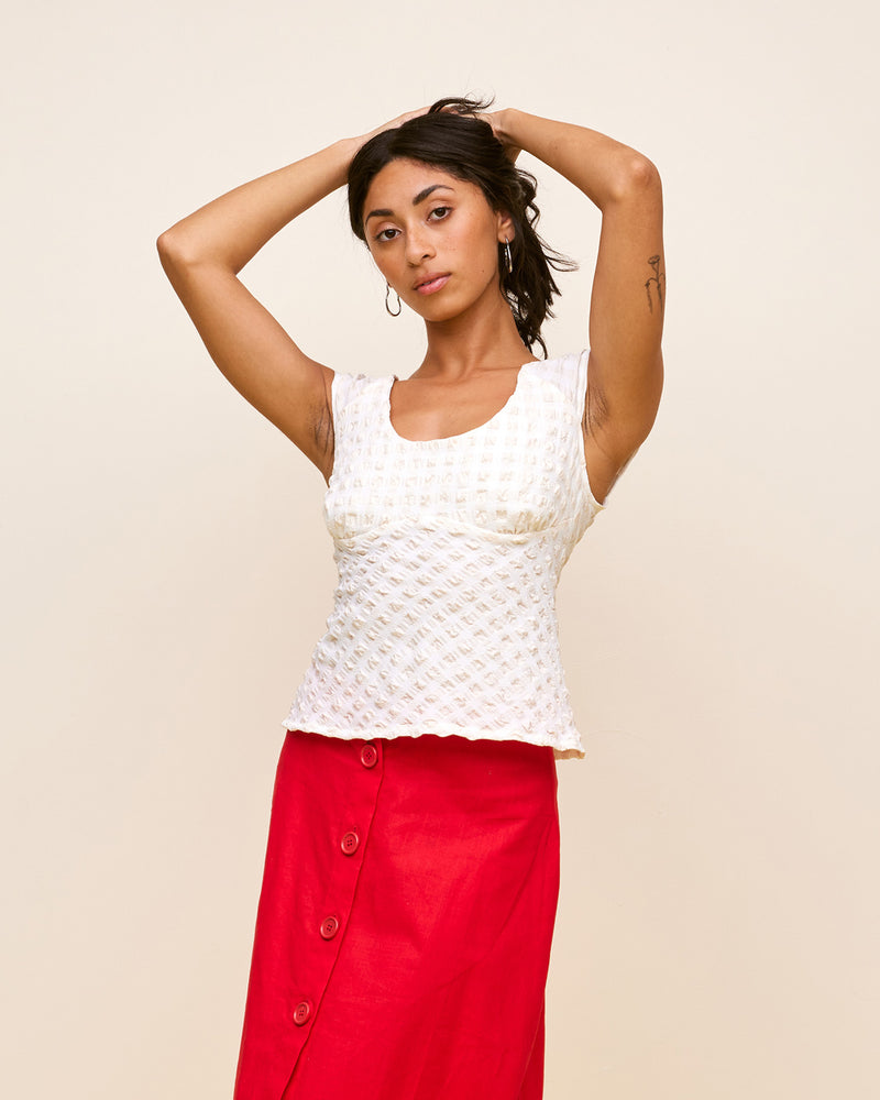 PRISM TOP NATURAL | Cap sleeve top cut in a stretch gingham fabric that has a gathered, seersucker texture. The round neckline falls to be scooped at the back. This top is an easy...