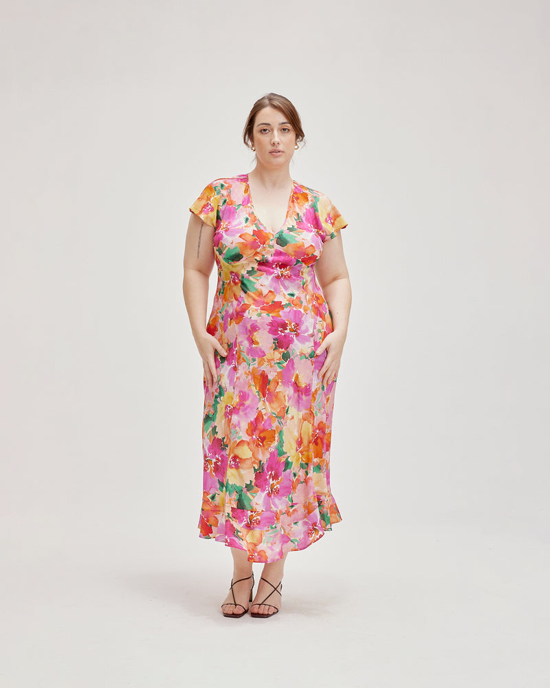 KATA SILK MIDI DRESS FLORAL | Bias cut midi dress with soft cap sleeves and a ruffled hem, crafted in a vibrant floral silk. The panelling in the dress creates a beautiful drape that complements the...