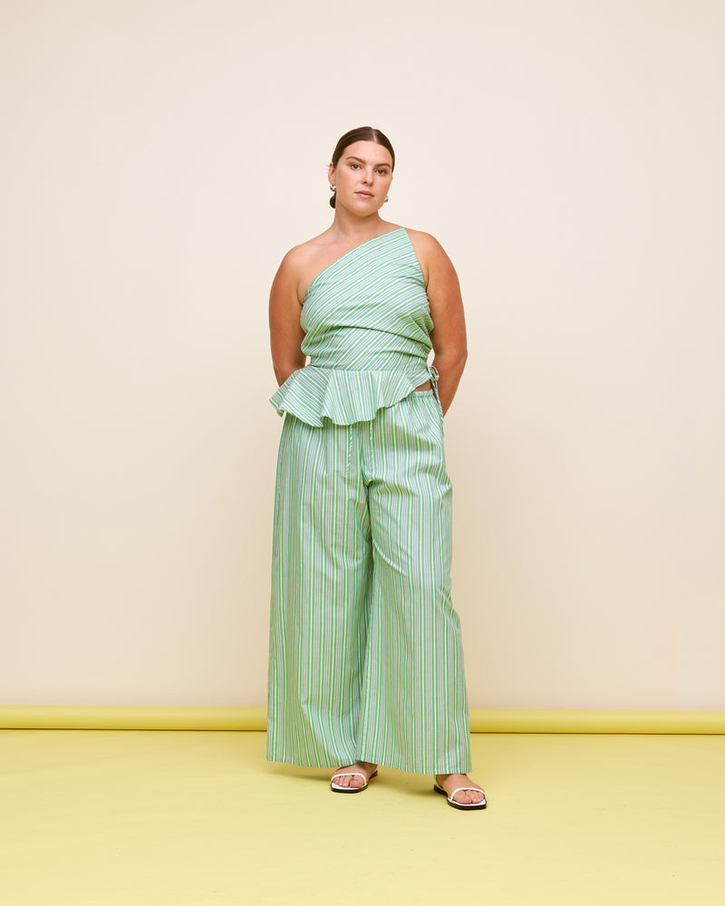 BETTINA COTTON TOP GREEN STRIPE | One shoulder cotton top with tie side gathering that can be cinched to adjust the length. The asymmetrical shape creates structure, while the peplum ruffle at the bottom hem adds...