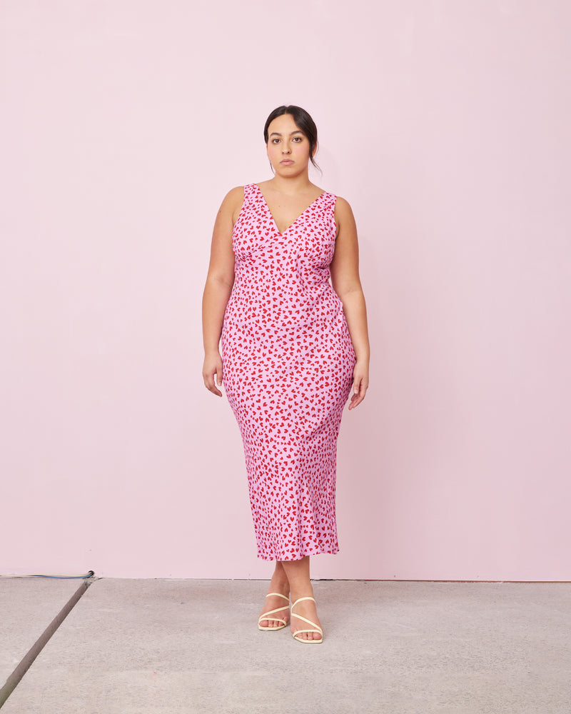 ESME SLIP DRESS PINK SCATTER HEARTS | Bias cut midi dress in a our RUBY 'scatter hearts' print. Wide straps and a panelled V-neck front and back give this dress a vintage shape. Features a waist tie...