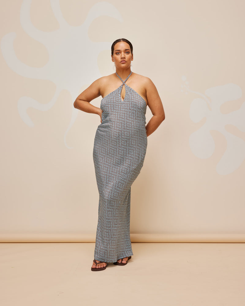 JEAN SILK SLIP GEOMETRIC PRINT | Bias cut silk halter midi slip designed in a blue geometric print featuring a keyhole front cut-out and back neck ties. The print contrasts the floaty nature of the fabric and...