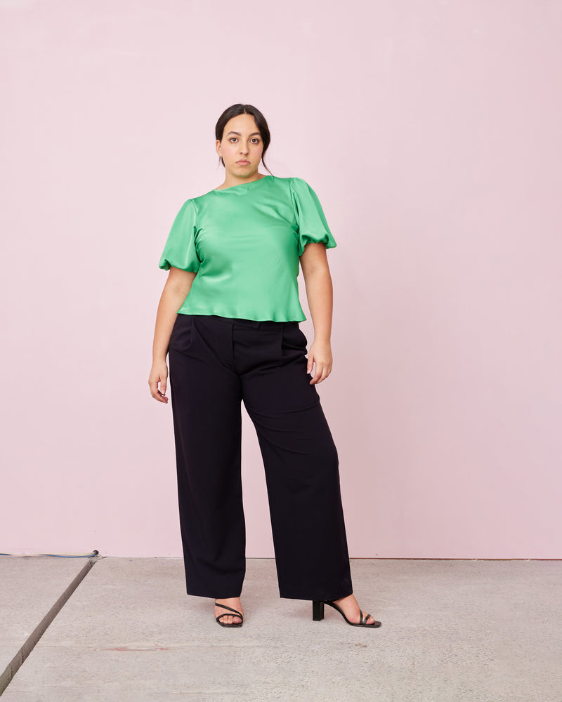 KENDALL SATIN TOP PARAKEET | Bias cut blouse with puff sleeves cut in a luxe emerald satin. It features keyhole button closure at back neck. The short sleeves are elasticated to create a voluminous puff...