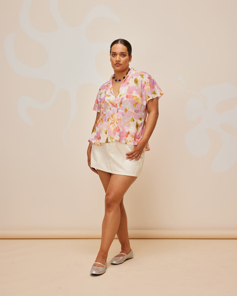 MORGAN BLOUSE BALLET FLORAL | Short sleeve chiffon blouse designed in our summery RUBY Ballet Floral print. Features a single-button closure at the front that overlaps to create a v-neckline, and a dropped waistline that creates...