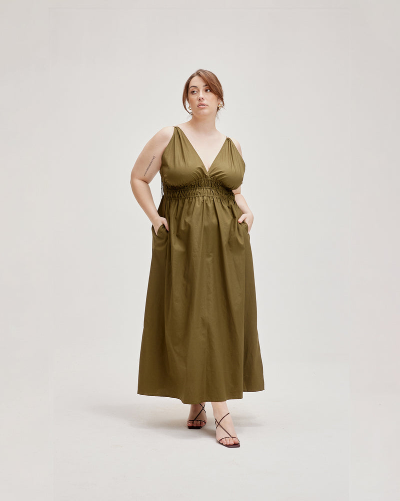 HERO MAXI DRESS OLIVE | Double strap maxi dress with a plungle neckline, shirred waist detail and side split in an olive cotton. The shirring at the waist accentuates the full skirt.