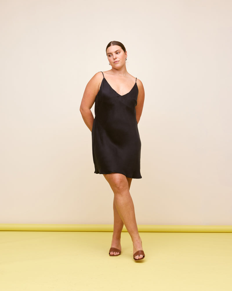  MAGNOLIA MINISLIP BLACK | V-neck mini slip designed in black, in our super soft magnolia cupro. This slip features a built-in waist tie to cinch in the waist as you wish.