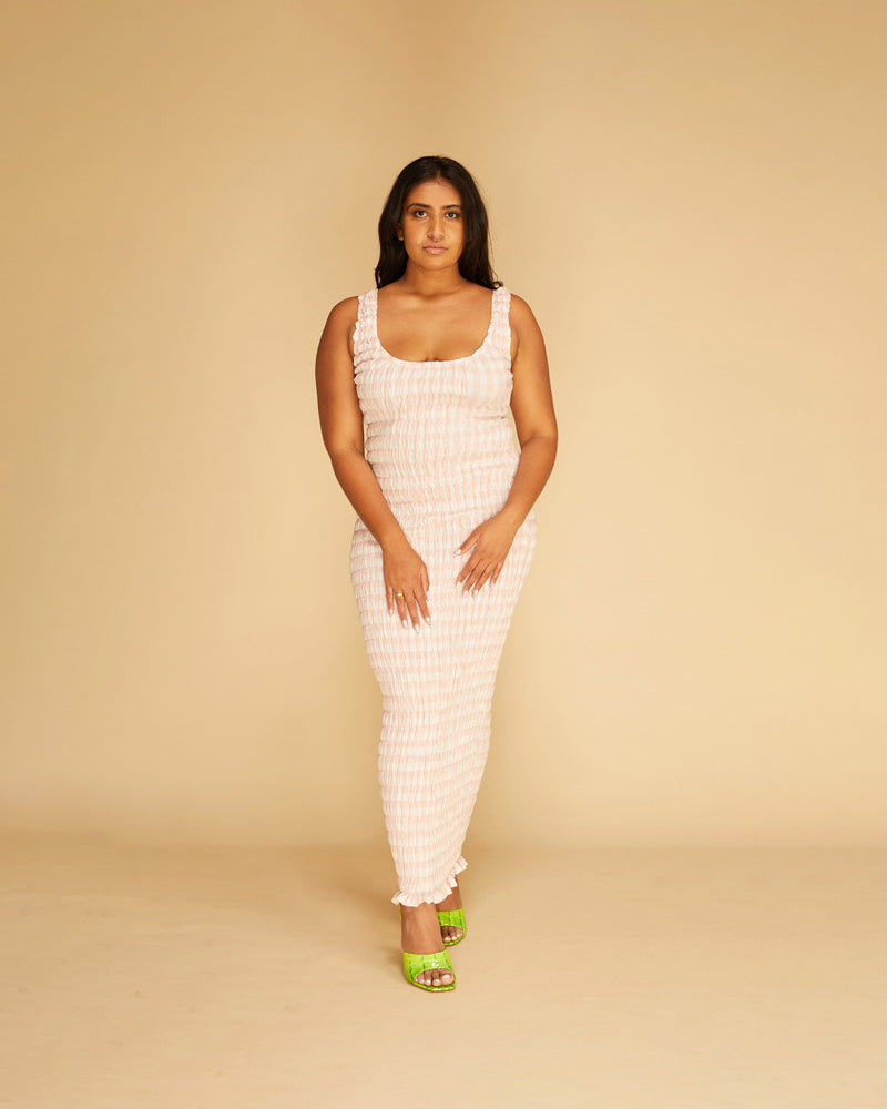 KLEIN GINGHAM MIDI DRESS PINK GINGHAM | Shirred midi dress with a scoop neckline and ruffle hem detail in a playful pink gingham. The shirring adds texture to the piece while also ensuring it fits closely to...