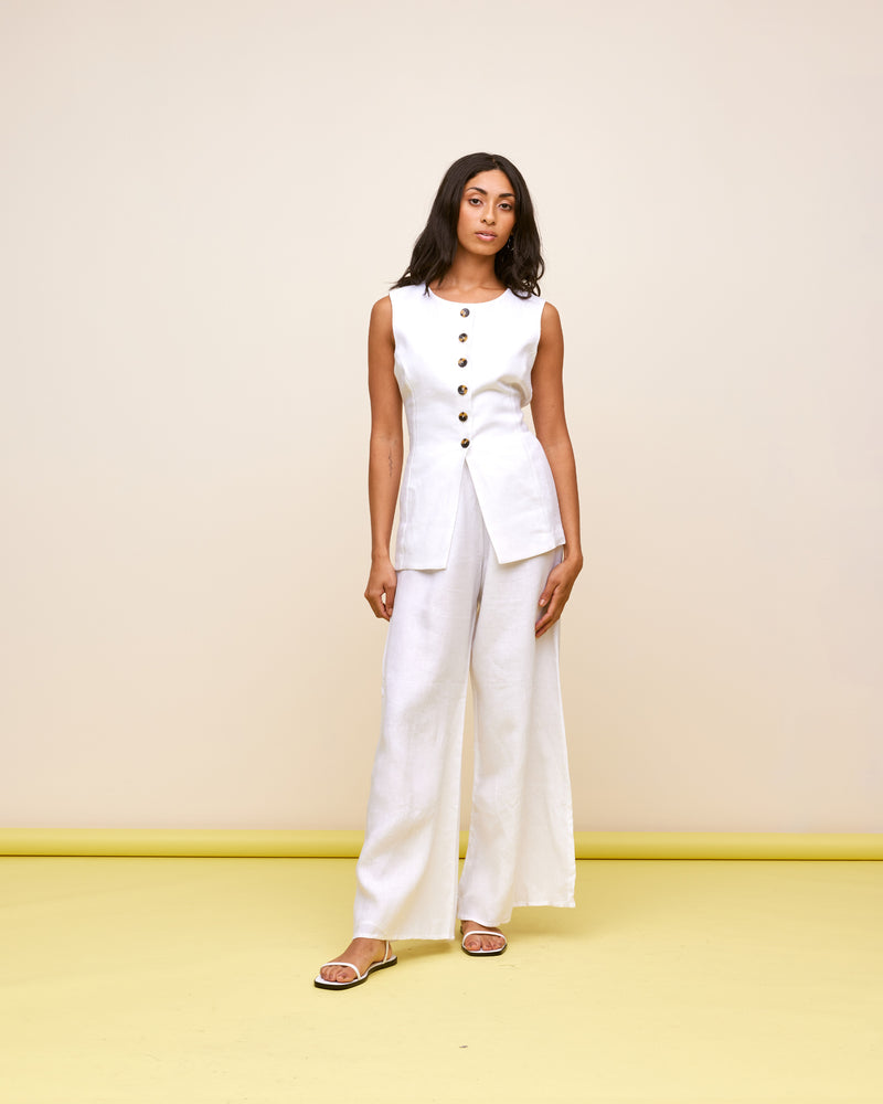 ALIZA LINEN VEST WHITE | Elevate your wardrobe with this staple linen vest. Featuring a round neckline with a button-down front, that finishes with an opening at the hem. Style this piece on its own...