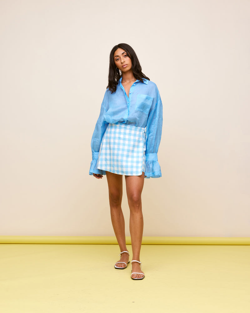  VIDA LINEN MINISKIRT BLUE LINEN GINGHAM | Linen wrap miniskirt designed in a blue and white gingham. This skirt is versatile in that it can be worn high or low waisted.