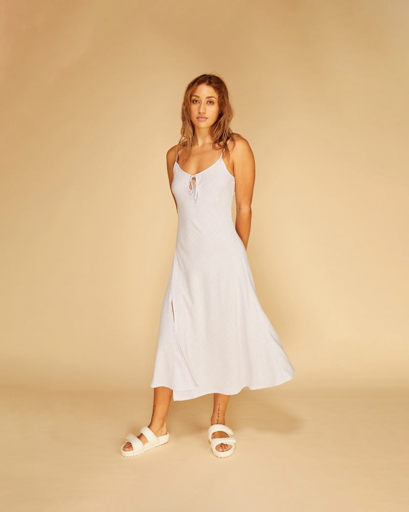 UMA SLIP LILAC GINGHAM | Bias cut slip dress with a front keyhole and tie detail imagined in a dainty lilac gingham. This piece flares slightly towards the bottom hem and features a side slip,...