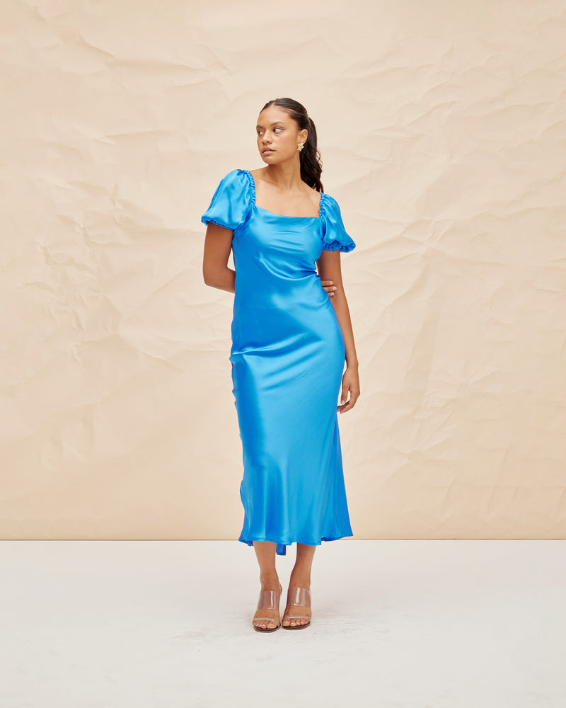 BOBBI SILK MIDI DRESS COBALT | Bias cut silk midi dress designed in a sheeny cobalt blue. Features a straight neckline and puff sleeves that compliment the vibrant blue shade.