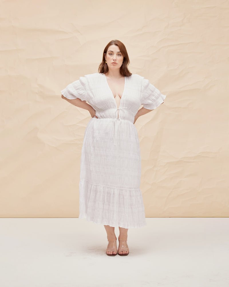 MIRELLA V-NECK DRESS WHITE | Short sleeve midi dress with a deep V-neckline and a double drawstring waist in the signature Mirella fabric, a delicate embroidered cotton. A timeless silhouette appropriate for every occasion.