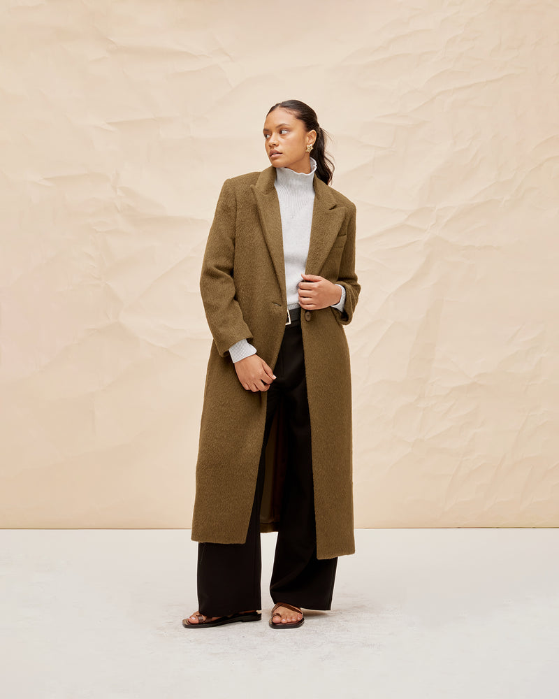 AUGUST COAT KHAKI | Longline coat with a double breasted collar and front pocket detail, cut in a plush handle in a khaki shade. Wearing this coat feels like being wrapped in a cosy...