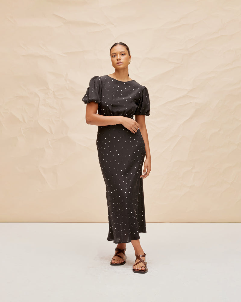 SYMPHONY SILK DRESS POLKA DOT | Bias cut silk midi dress with puff sleeves and a keyhole button closure at the back neck. The bias silhouette of this dress gently contours the body, while the polka dot silk provides...