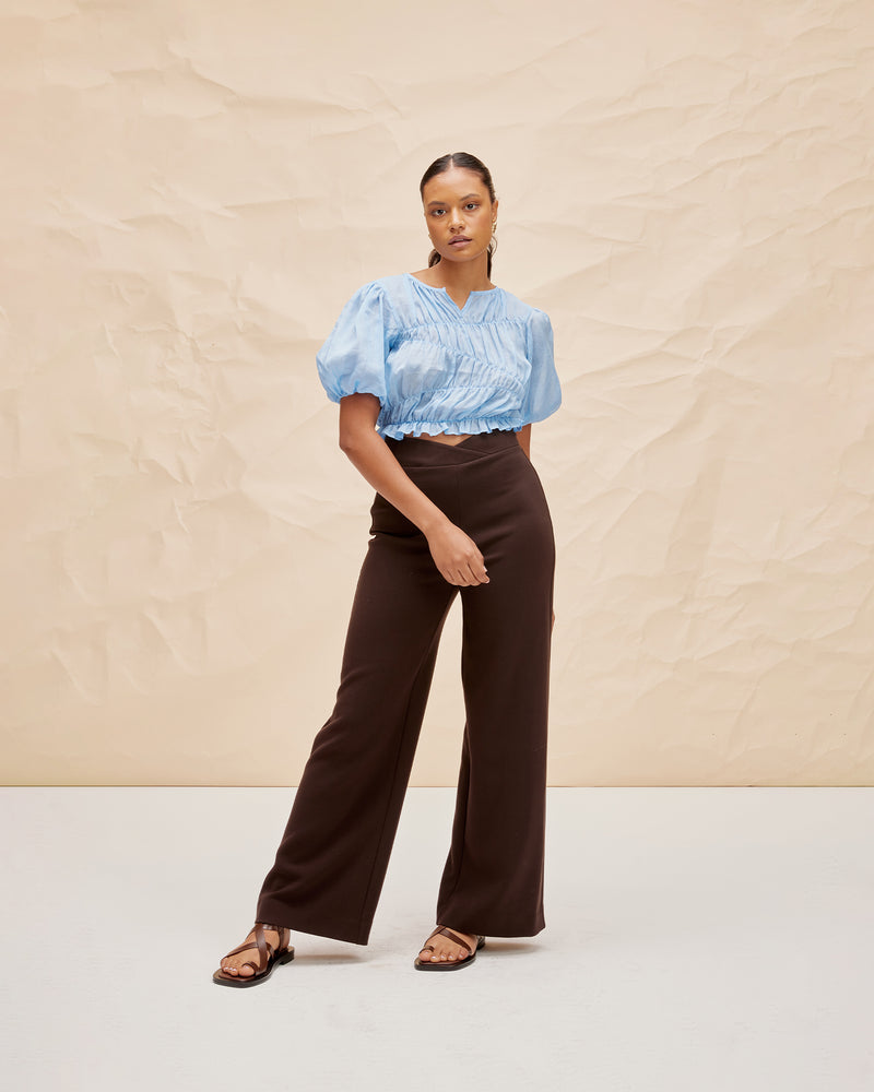 LILLIE TOP BLUE | Elasticated crop blouse with with puff sleeves and a frill hem, made from a delicate translucent ramie voile. The elastic detail creates texture in the piece, and contrasts with the...