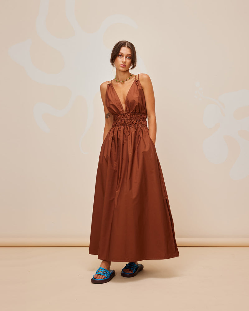 HERO MAXI DRESS CHOCOLATE | Double strap maxi dress with a plunge neckline, shirred waist detail, and side split in a chocolate coloured cotton. The shirring at the waist accentuates the full skirt.