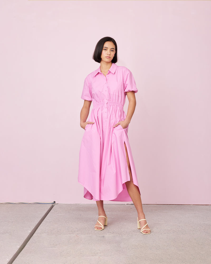 COMET SHIRT DRESS ORCHID | Maxi shirt dress crafted in a pink orchid cotton with an elasticated waist and short sleeves. The fully functional buttons allow you to show as little or as much skin...