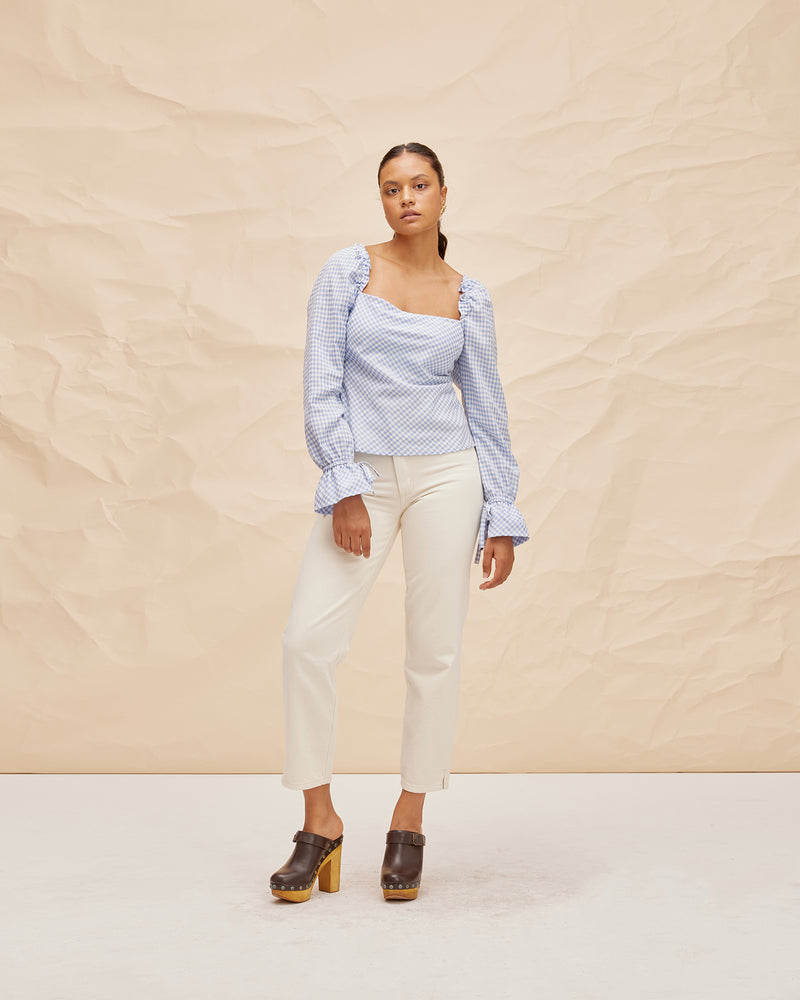 BON GINGHAM TOP BLUE GINGHAM | Longsleeve sqaure neck gingham blouse with a puff detail at the shoulder and gathered frill at the cuff. Cut in a baby blue gingham, this blouse is an effortless staple...