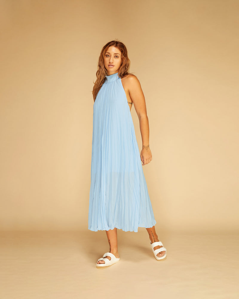 CASCADE CRUSH GOWN BLUE | Floaty halter neck midi dress with a low open back, pleats throughout and long self-tie straps at the back neck. Crafted in a crushed sky blue, this piece is both...