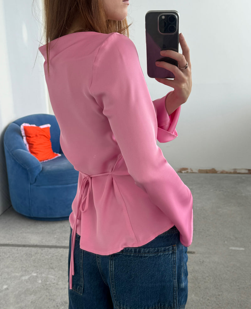 ANDIE SATIN BLOUSE PINK | Flared sleeve satin blouse designed in a lush candy pink satin. This top has a cowl neckline and tie detail at the waist. Find out more about this garments quirk...