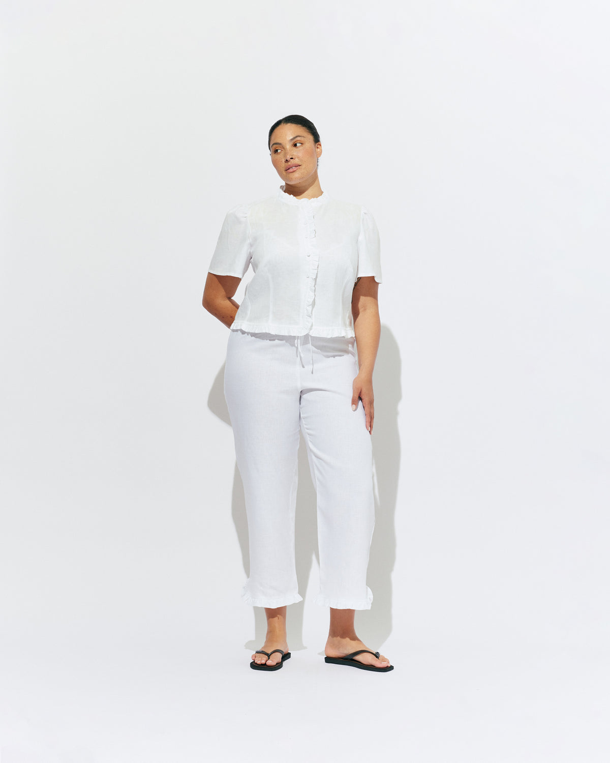 ARLO LINEN TOP WHITE | White linen button up blouse with ruffle detailing around the neckline, hem and down the front. A great addition to your workwear wardrobe, pair with denim for a sweet and simple look. 