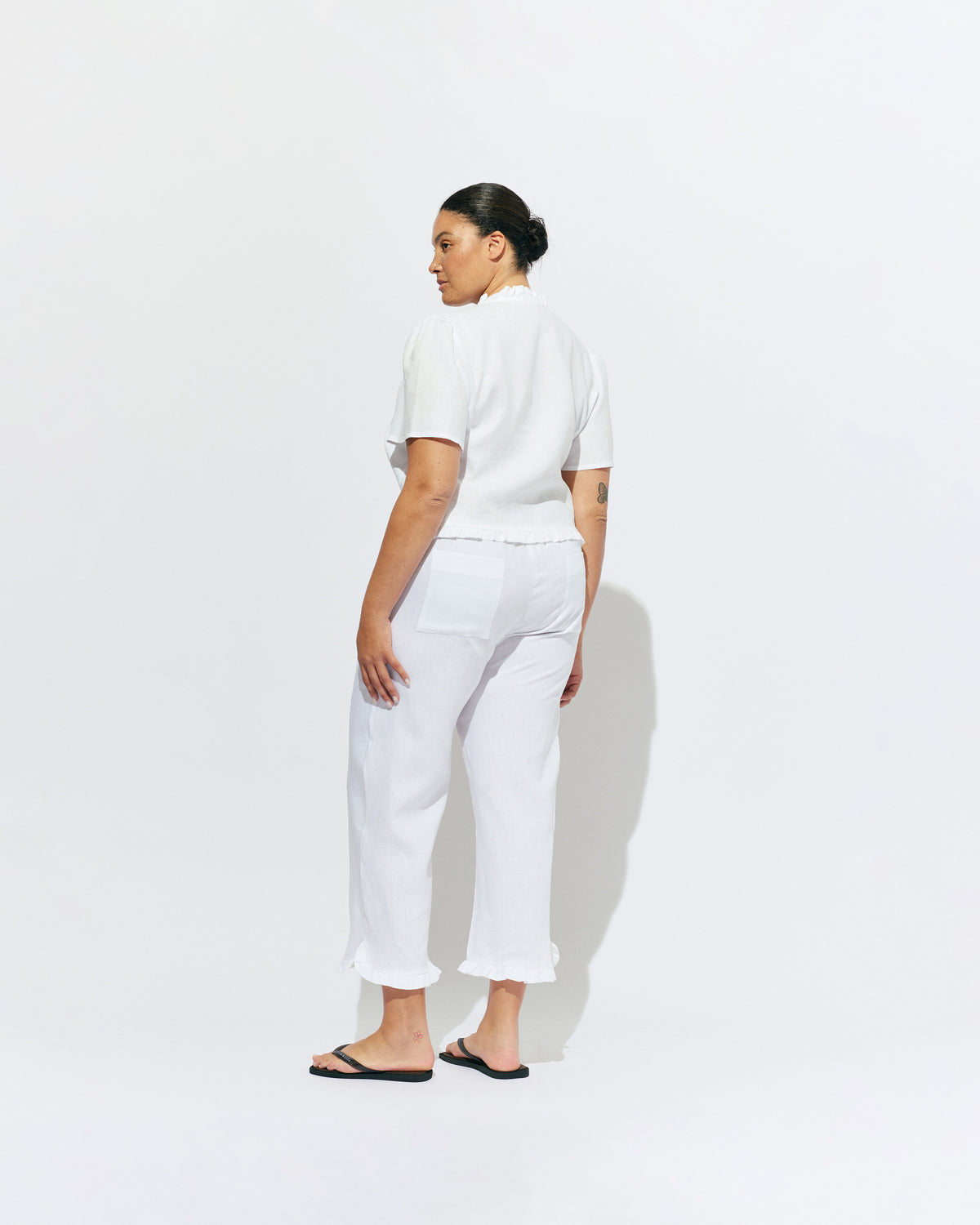 ARLO LINEN TOP WHITE | White linen button up blouse with ruffle detailing around the neckline, hem and down the front. A great addition to your workwear wardrobe, pair with denim for a sweet and simple look. 