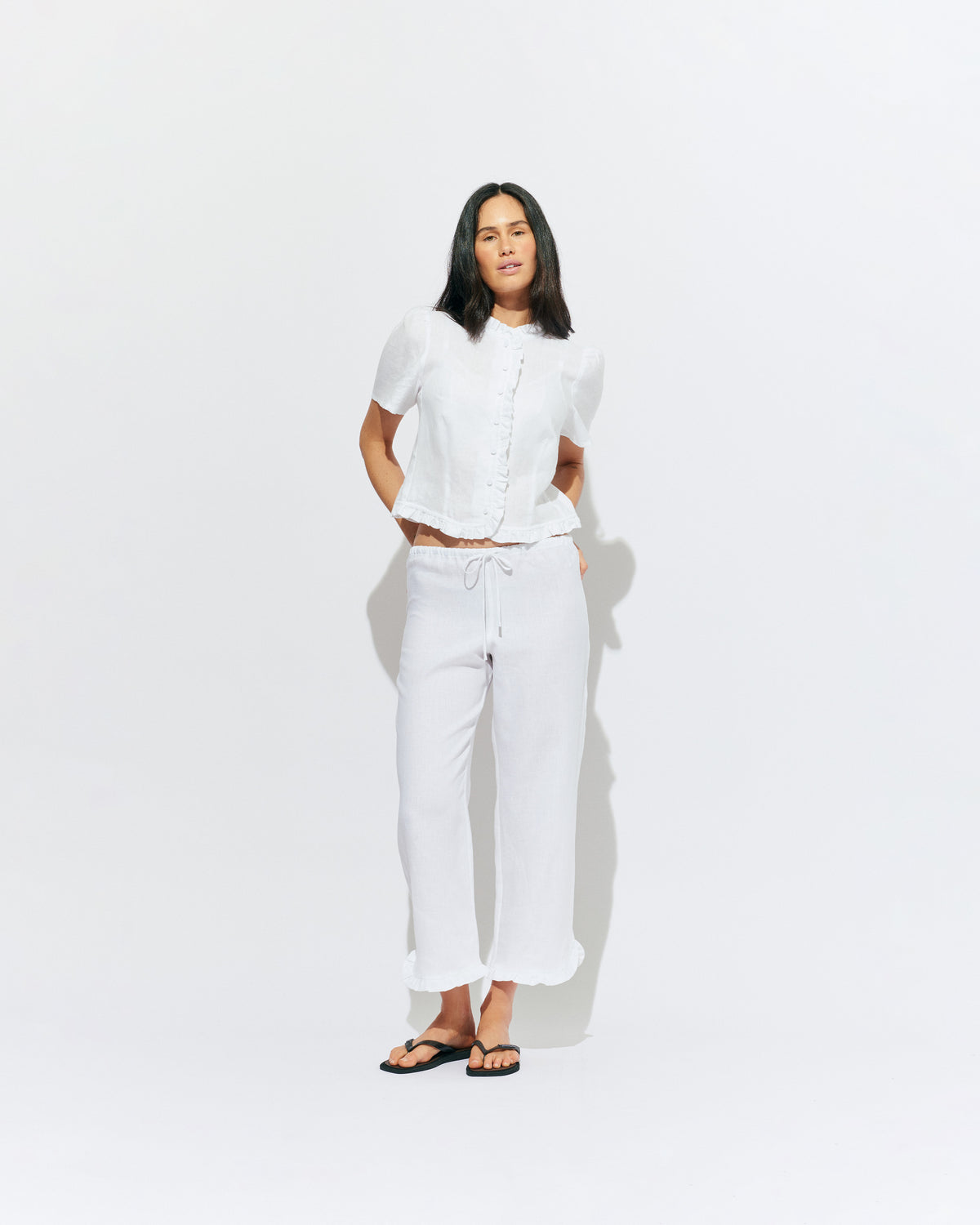 ARLO LINEN TOP WHITE | White linen button up blouse with ruffle detailing around the neckline, hem and down the front. A great addition to your workwear wardrobe, pair with denim for a sweet and simple look. 