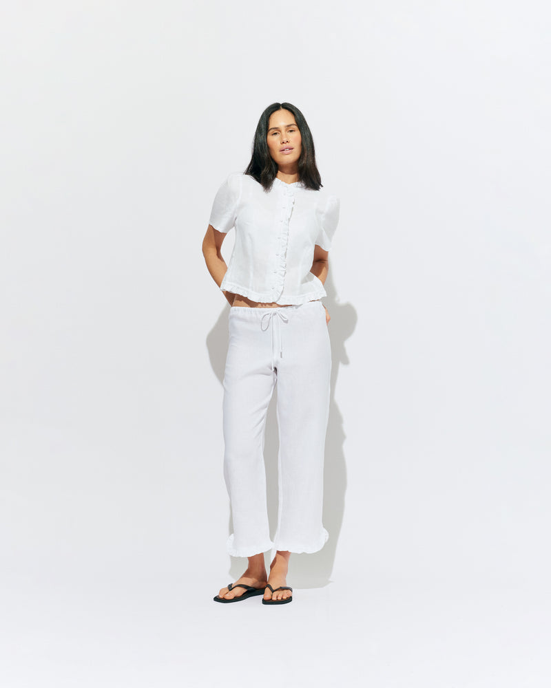 ARLO LINEN TOP WHITE | White linen button up blouse with ruffle detailing around the neckline, hem and down the front. A great addition to your workwear wardrobe, pair with denim for a sweet and simple look. 