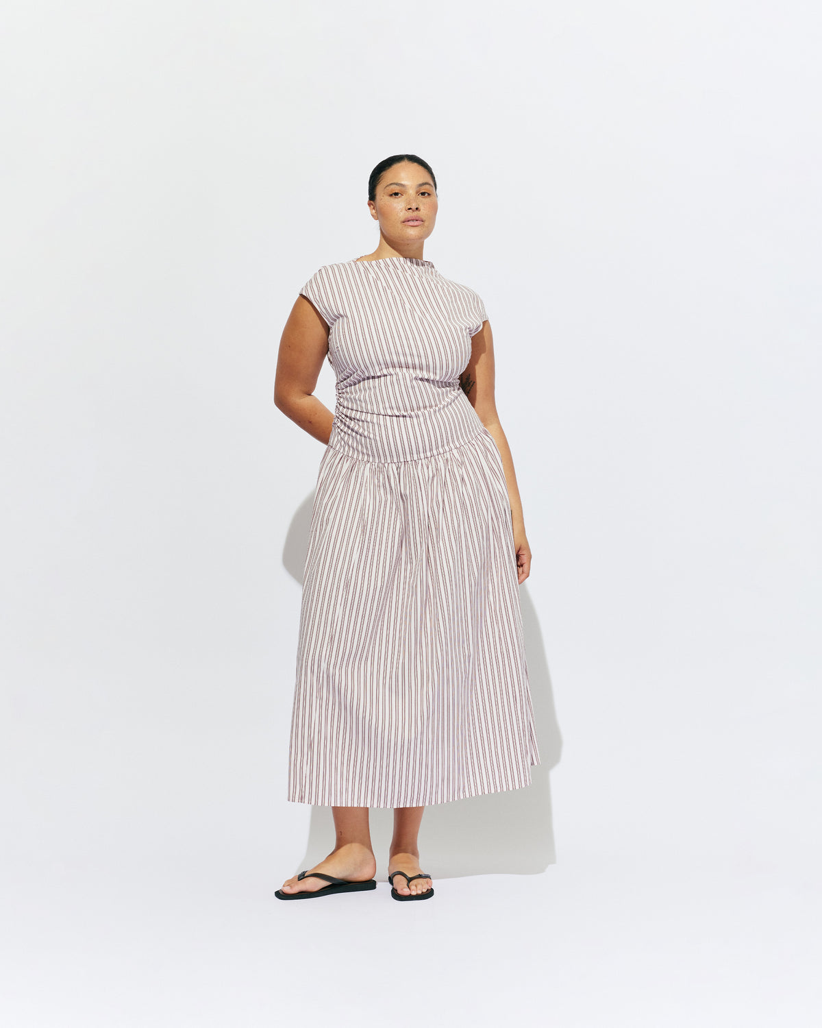 BIRDIE MAXI DRESS PINK LADY STRIPE | Drop waist maxi dress designed in our organic cotton pink lady stripe. Featuring a high neck collar, pleated skirt and a gather detail on the lower back designed for better fit and movement. Layer with one of our Blazers for...